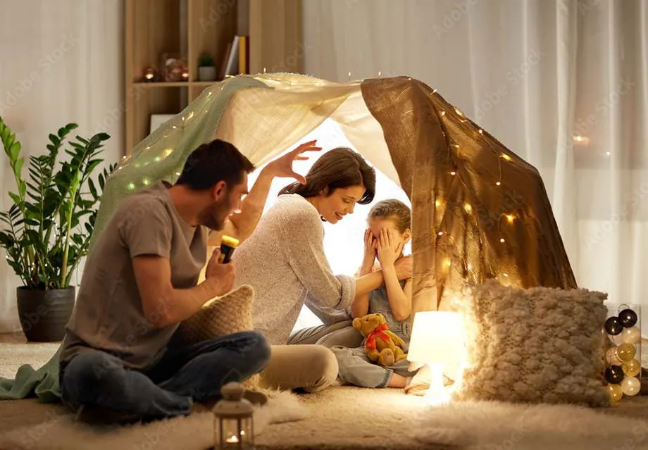 A family relaxing together in a cosy tent at home